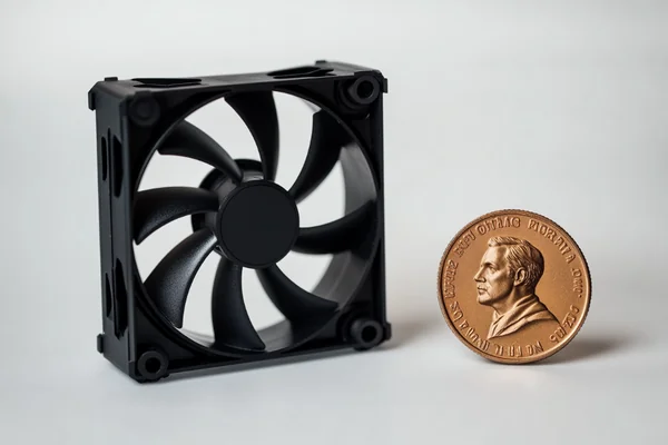 A small 25mm fan next to a coin for scale