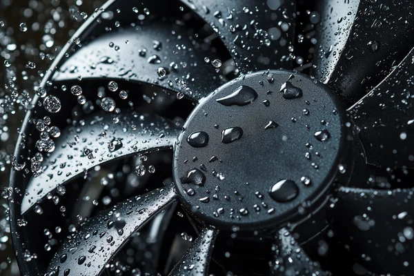 A waterproof DC axial fan with water splashing on it