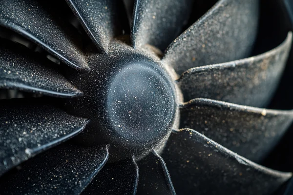 Close-up of a dusty and worn-out DC fan blade.
