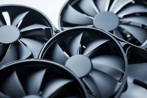 Close-up product photography of three DC axial fans with different blade counts - a 3-blade, 7-blade, and 11-blade fan - arranged side by side showing the visual difference in blade density