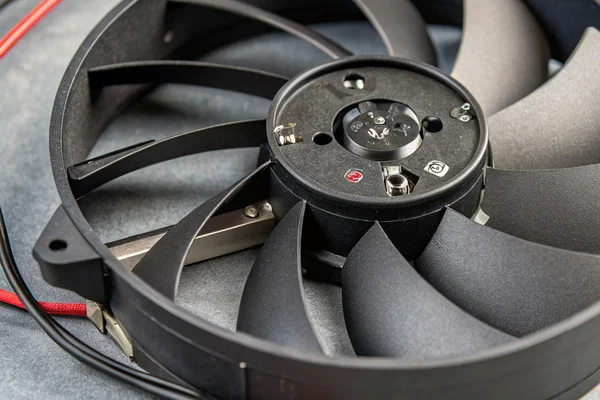 A DC axial fan's round frame and curved blades shown in close-up product photography