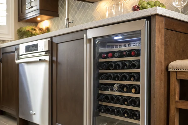 A wine cooler installed in a built-in kitchen cabinet showing restricted condenser airflow clearance