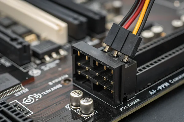 Close-up of a 4-pin PWM connector being inserted into a motherboard fan header, showing the black plastic housing and pin contacts