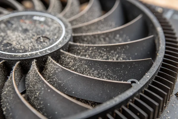 Close-up of dust accumulation on a gaming console heat sink fins and fan blades