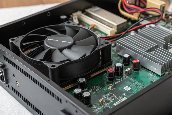 DC axial cooling fan installed inside an open audio power amplifier chassis, with visible heatsink fins and circuit board
