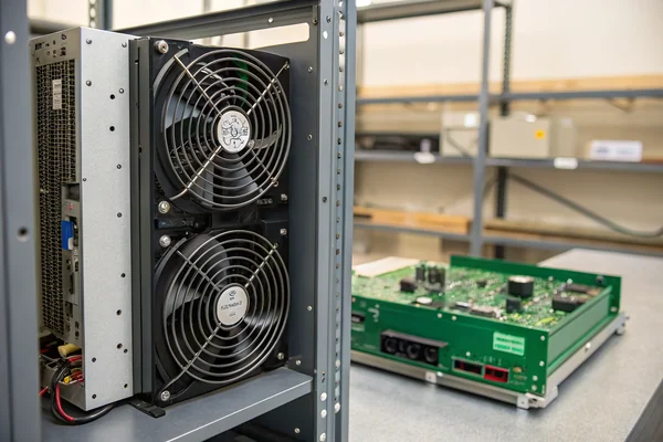 DC axial fan installed in a server rack panel alongside a DC blower unit mounted flat against a circuit board inside an industrial enclosure