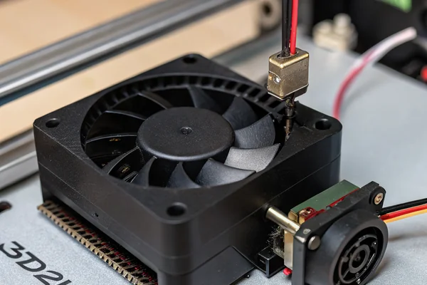 Small DC blower fan with attached cooling duct shroud mounted on a 3D printer hot end, positioned near the nozzle