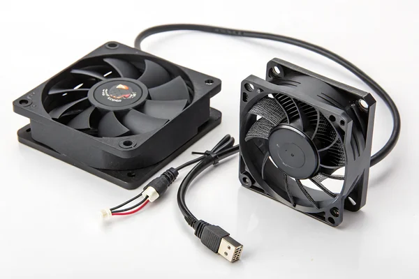 Close-up comparison of an AC fan power cord plug next to a DC fan's low-voltage connector on a white background