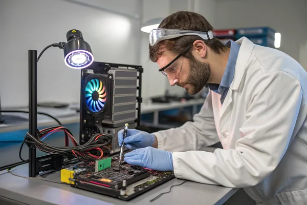 Engineer testing an ARGB fan's compatibility against multiple different motherboard headers on a test bench