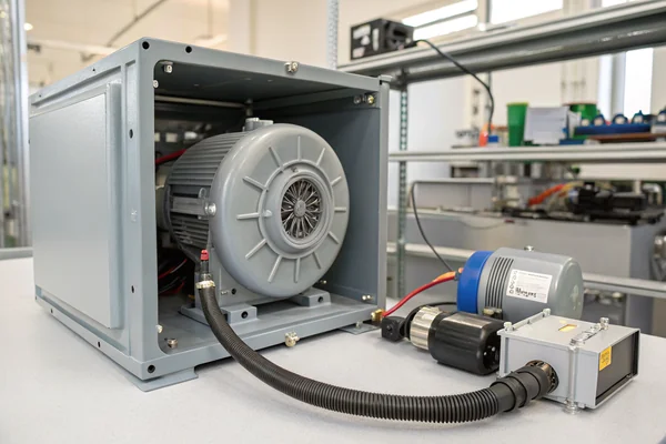 DC brushless blower with sealed housing mounted inside an open fuel cell system enclosure, tubing connecting to the stack visible