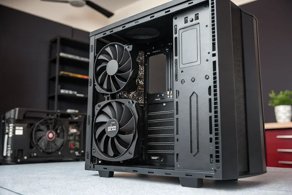 Large 200mm black PC case fan mounted in a side panel intake position of an open computer case, showing scale against nearby components