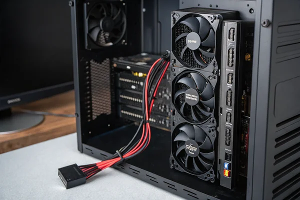 Black PWM fan hub circuit board with multiple fan cables connected, SATA power cable visible, mounted inside a PC case